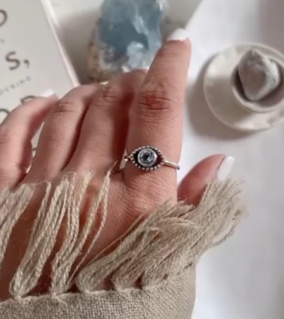 Close-up of evil eye boho silver ring with intricate design and blue topaz
