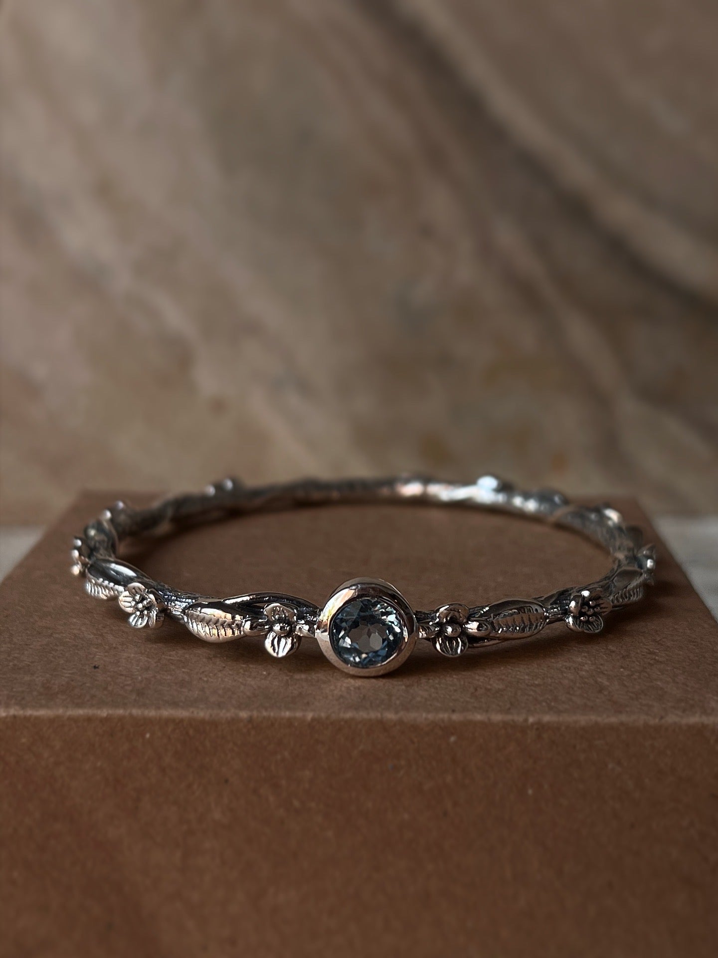 Artisan 925 sterling silver bangle with blue topaz forest design