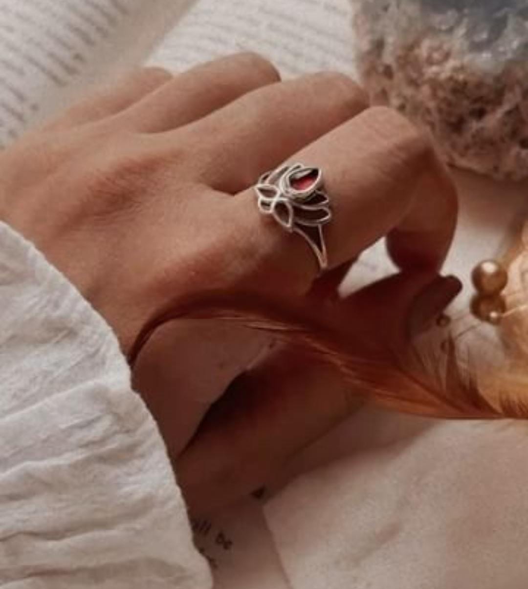 Silver ring featuring a divine lotus design with a garnet center