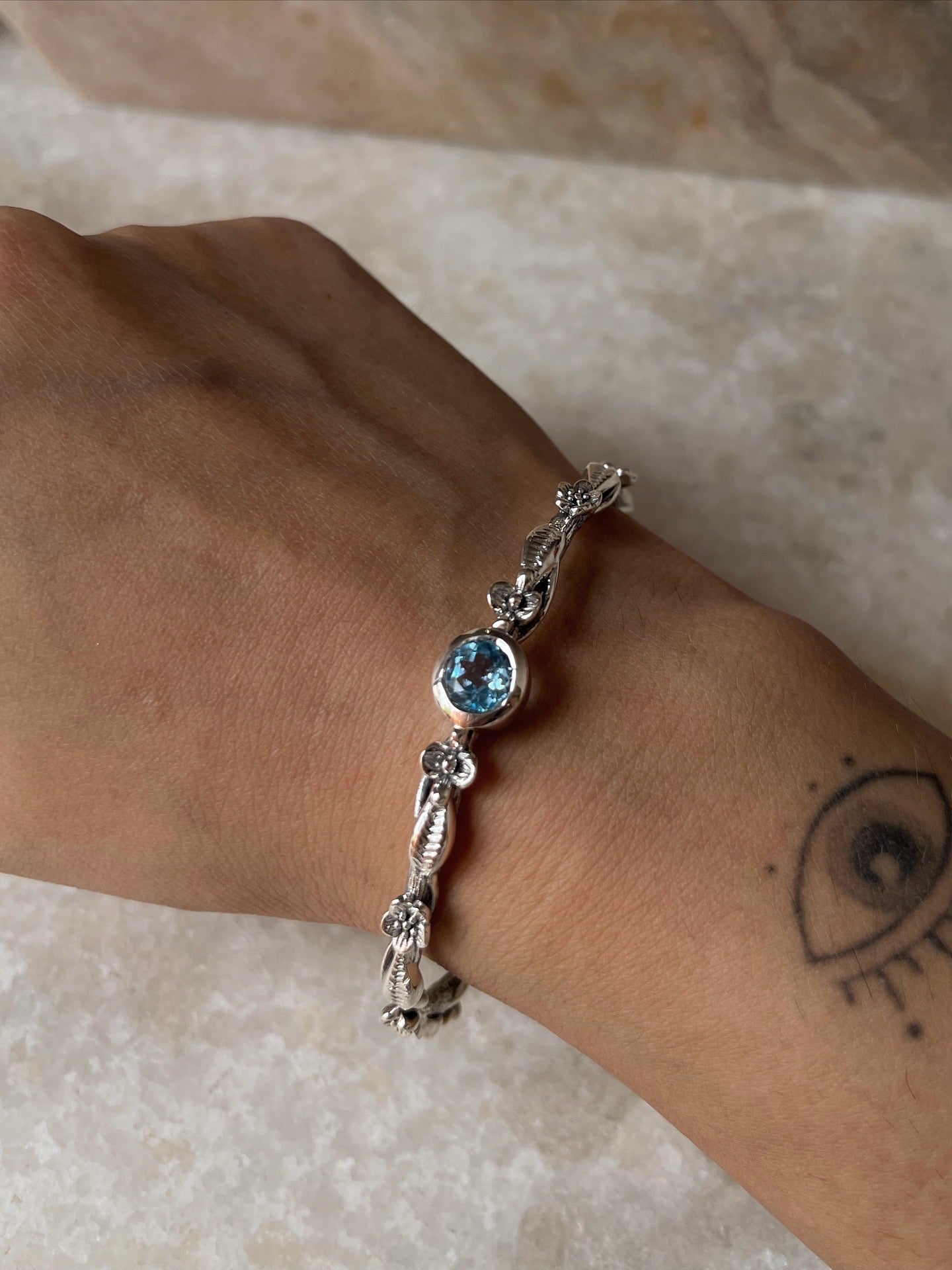Handcrafted sterling silver bangle with blue topaz gemstone