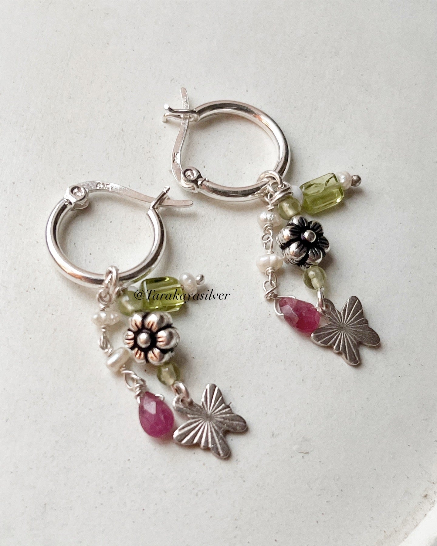Delicate silver hoops with peridot, pearl, and pink tourmaline charms