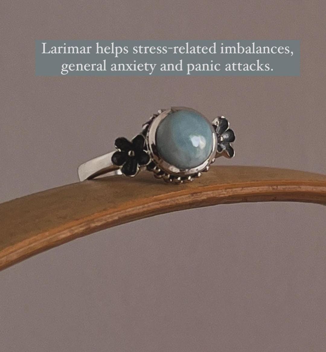 Larimar gemstone set in a silver ring with delicate cherry blossom design