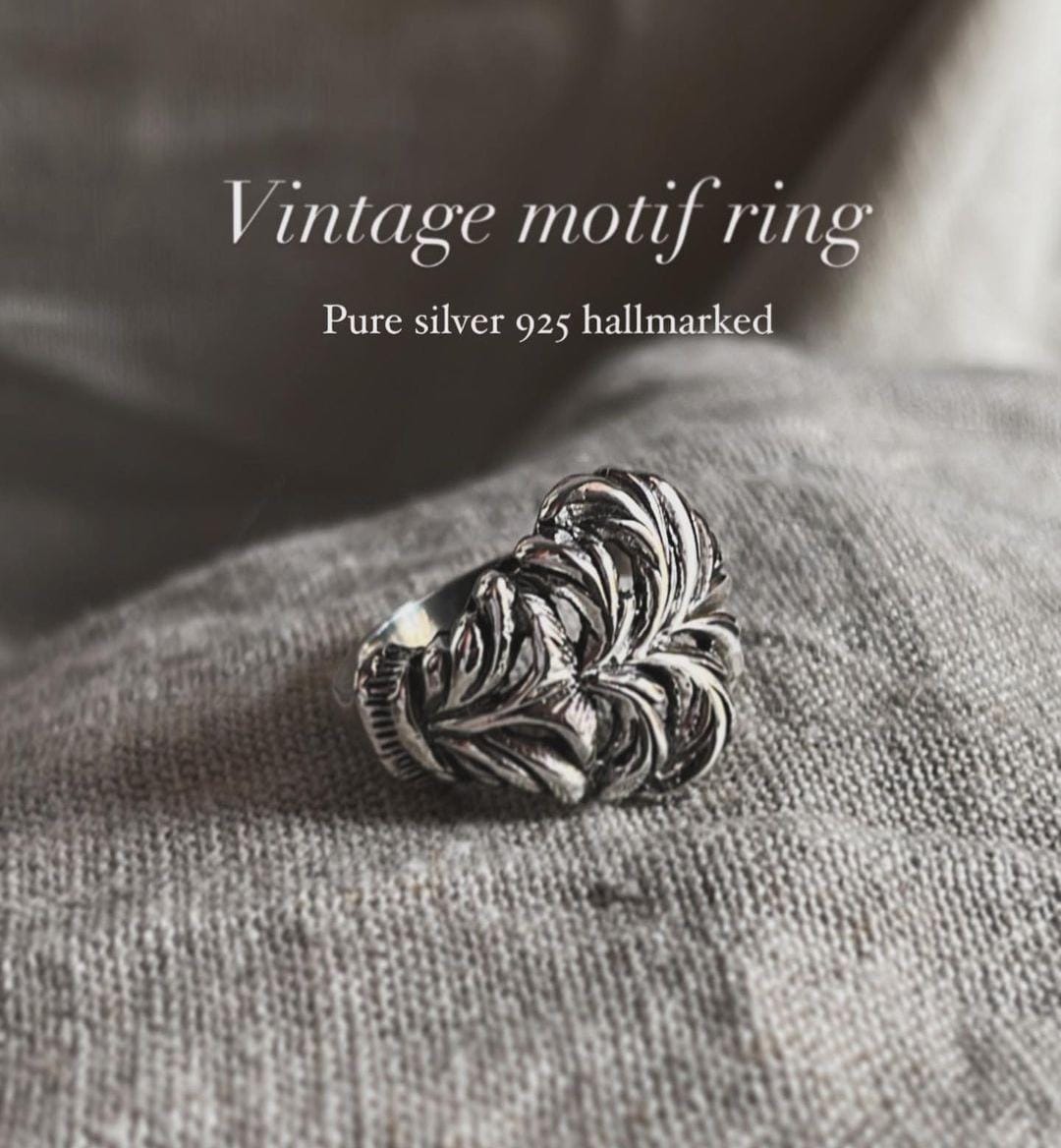 Close-up of chunky band ring with vintage-inspired motif design