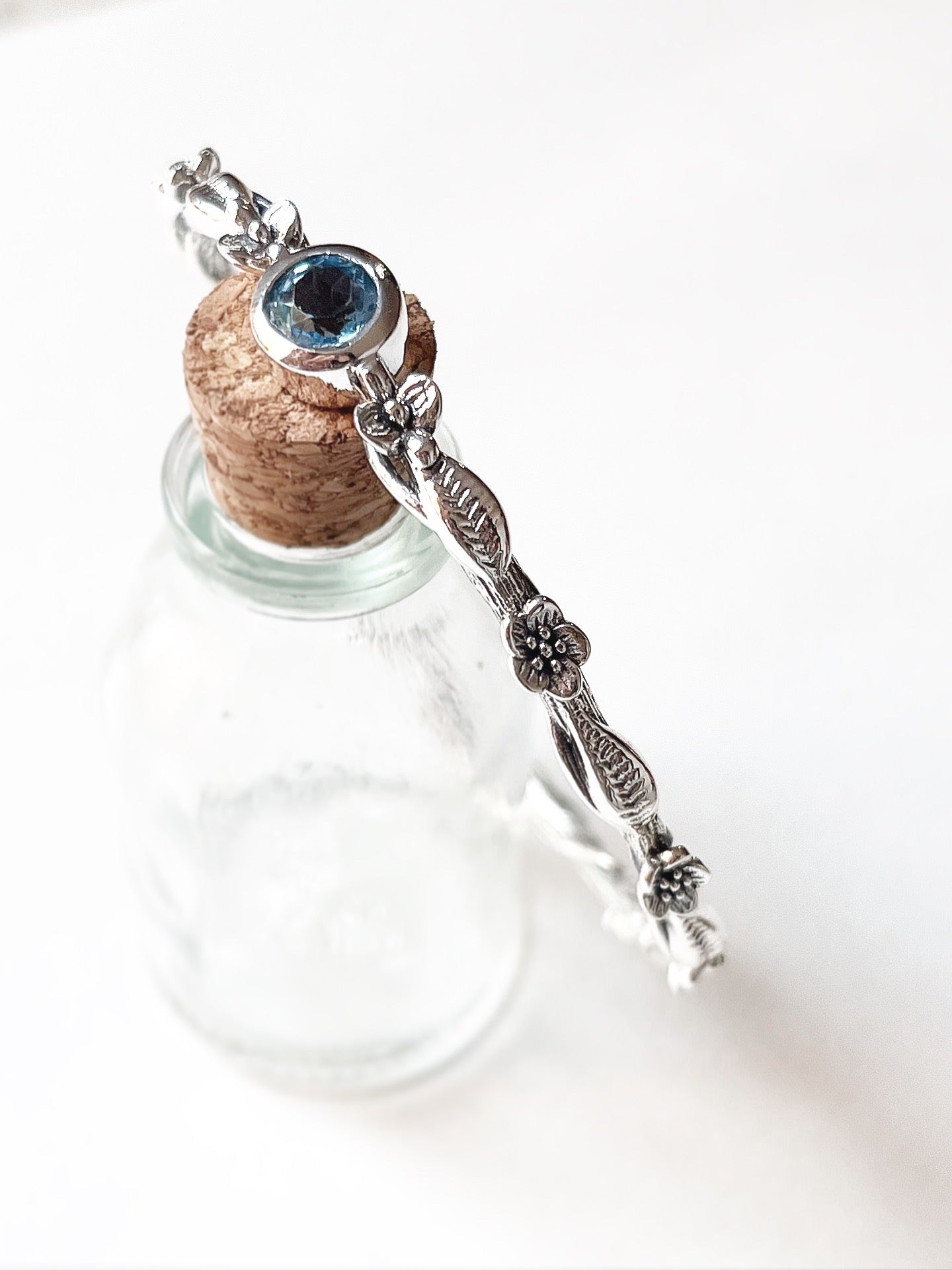 Nature-inspired sterling silver bangle with blue topaz