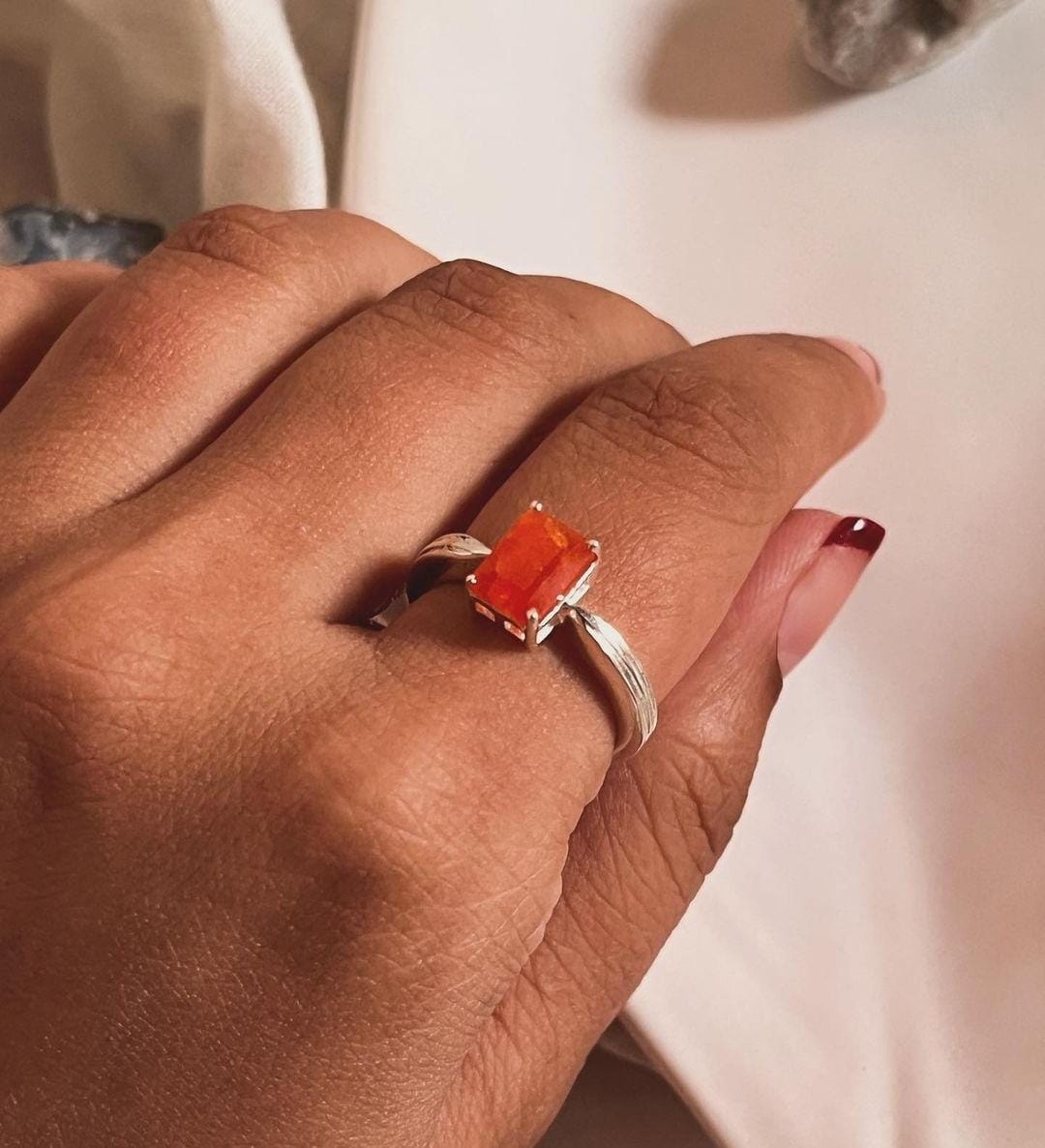 Close-up of carnelian rectangular gemstone in a silver ring