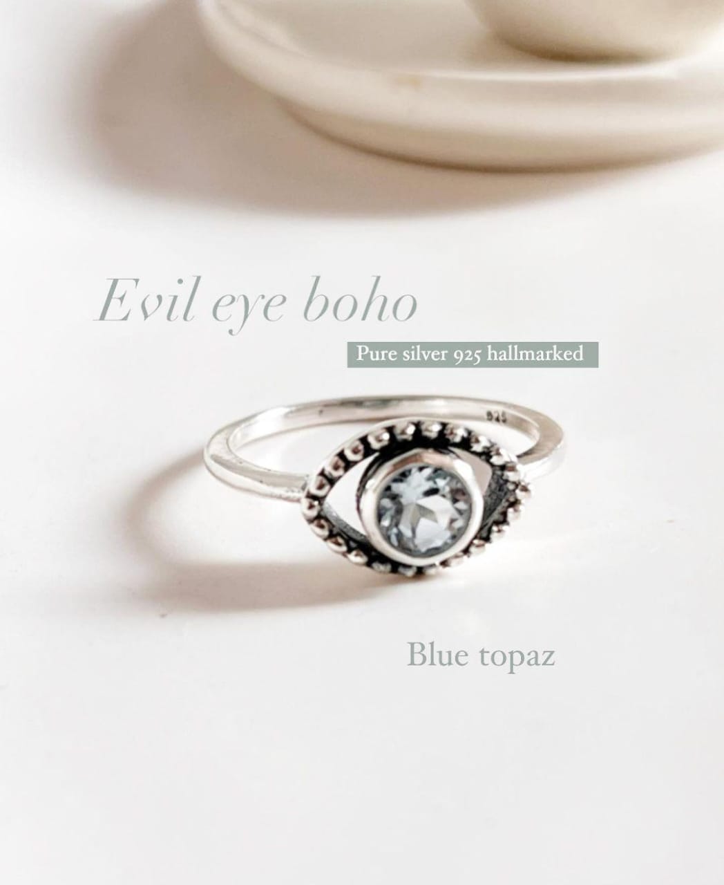 Charming evil eye boho silver ring with vibrant blue topaz centerpiece