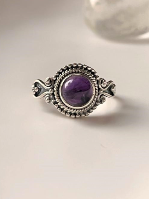Boho-inspired silver ring featuring a round amethyst gemstone.