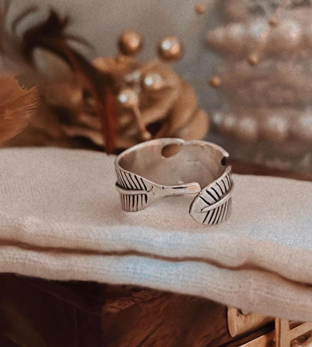 Close-up of feather wrap adjustable silver ring with a polished and smooth finish