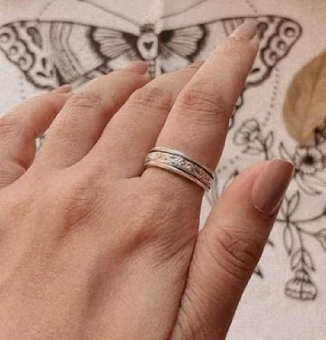 Charming floral spinner silver ring featuring a rotating floral band