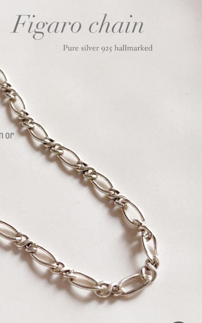 Close-up of Figaro neck silver chain with smooth, elongated links