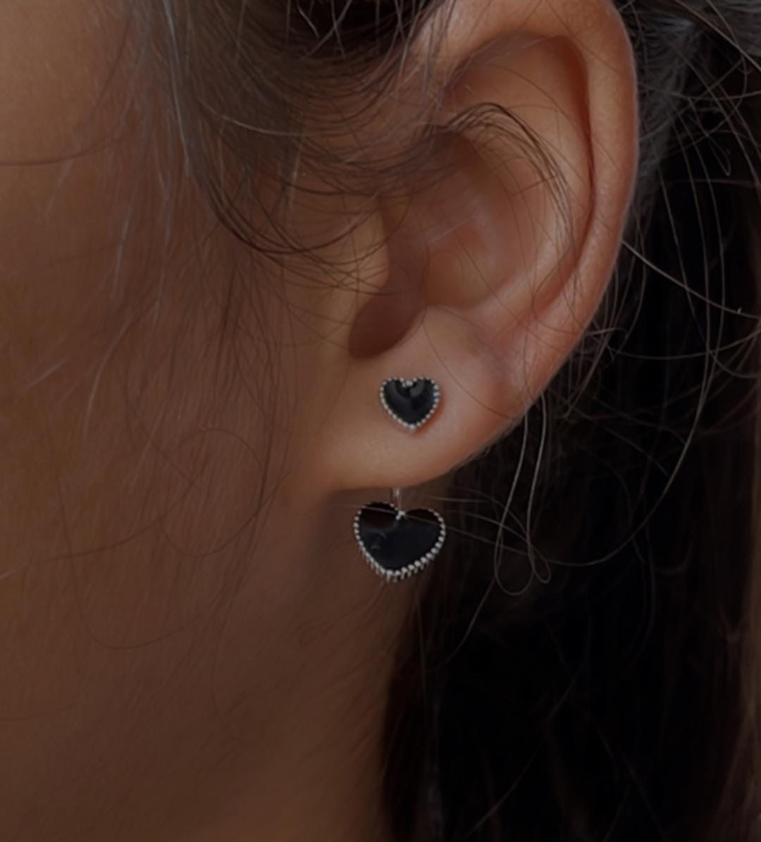 Sleek black heart enamel silver studs with modern design.