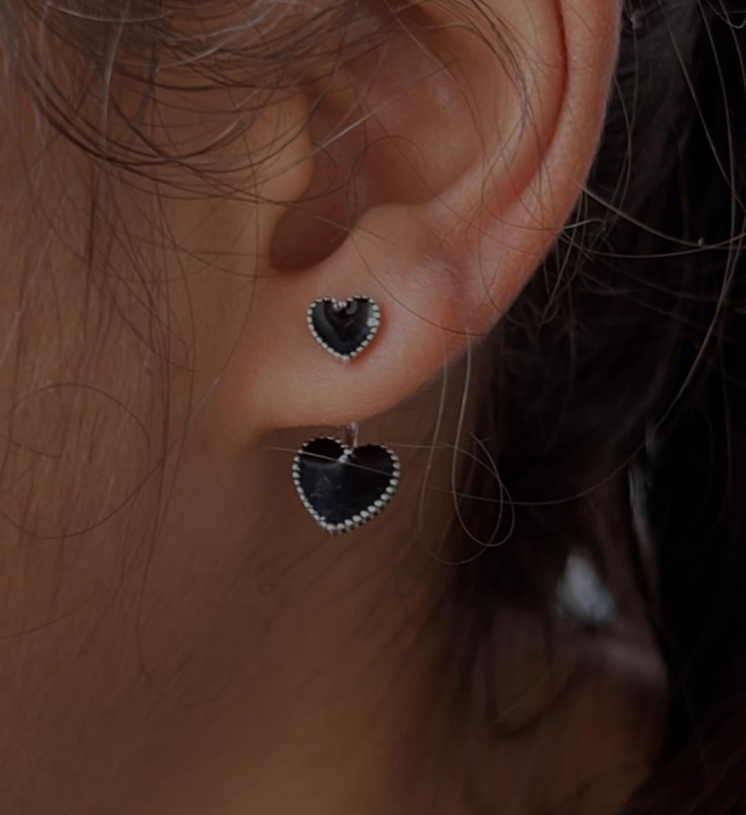 Charming black enamel heart-shaped silver studs for a bold look.