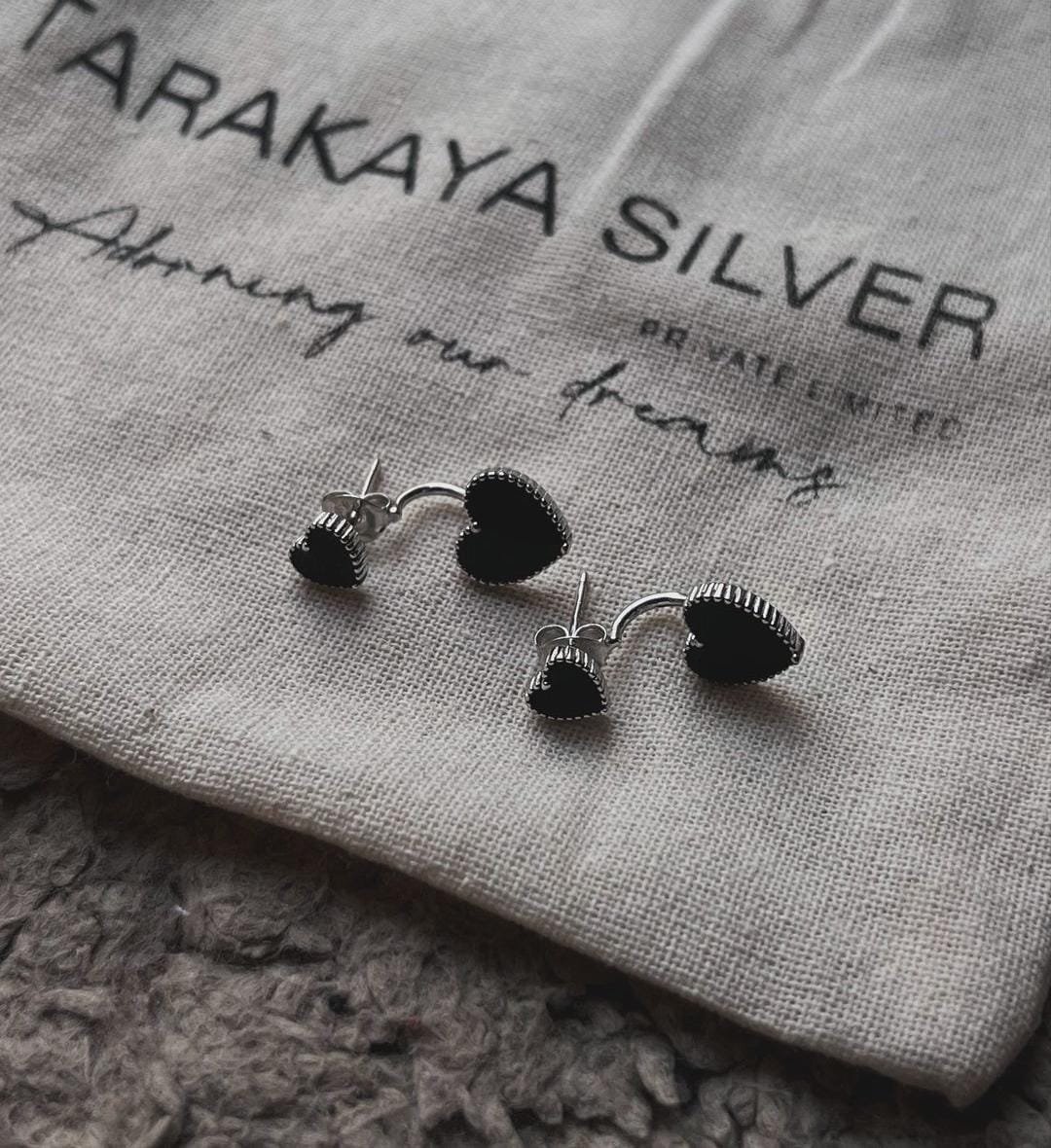Timeless silver studs featuring black heart enamel for a chic touch.