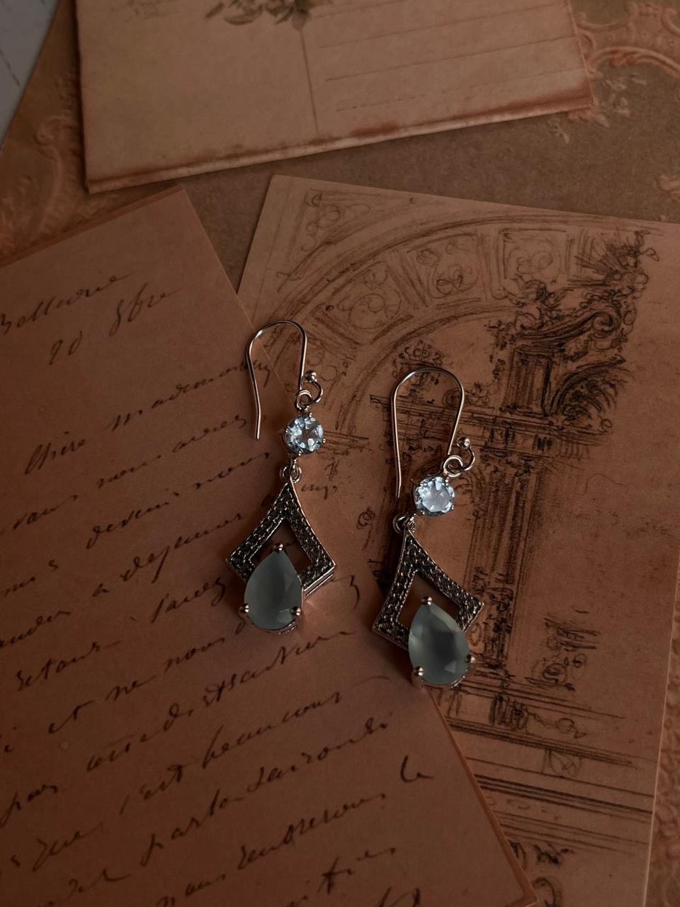 Elegant silver earrings featuring aqua chalcedony pear cut and blue topaz stones.