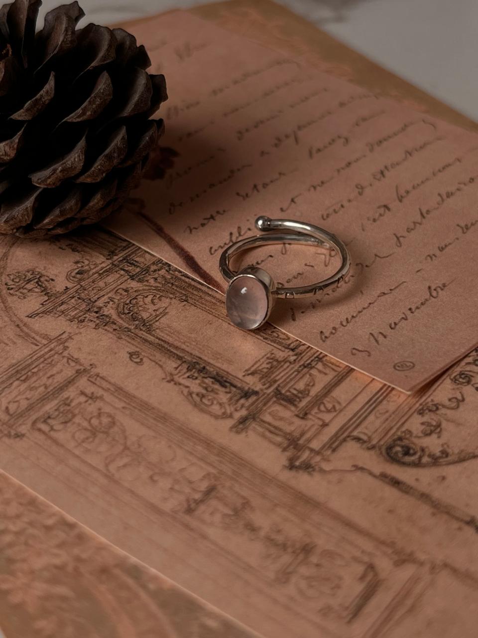 Delicate rose quartz oval ring with intricate tribal engravings in silver