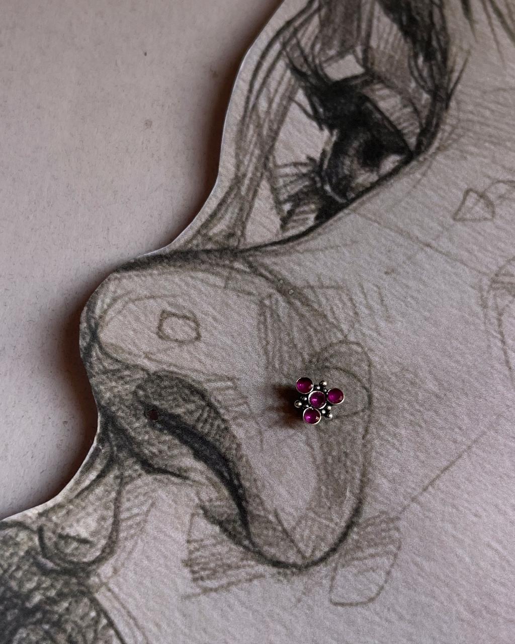 Close-up of handcrafted silver nose pin with pink cubic zirconia