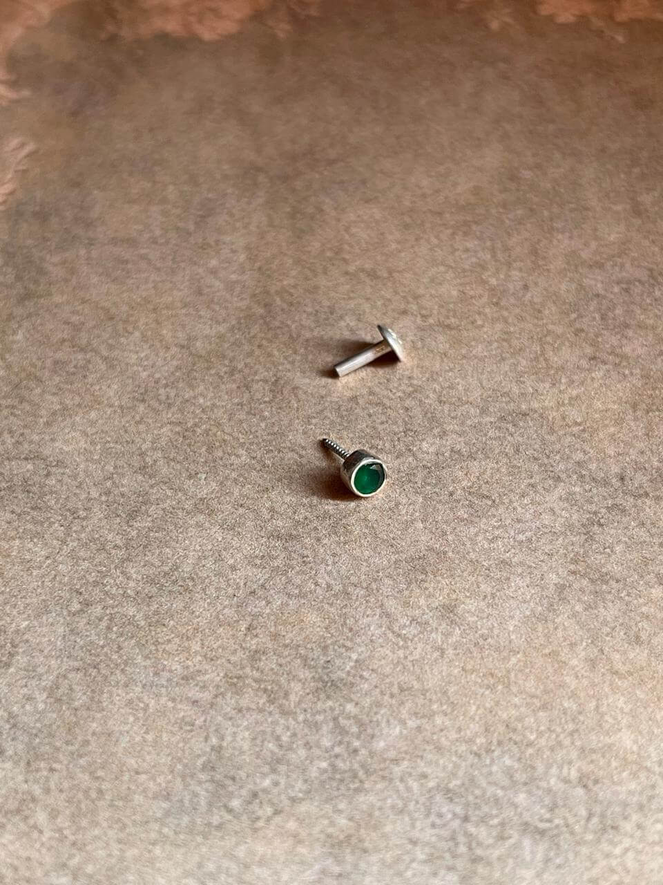 Close-up of Green CZ Screw Back Minimal Silver Nose Pin