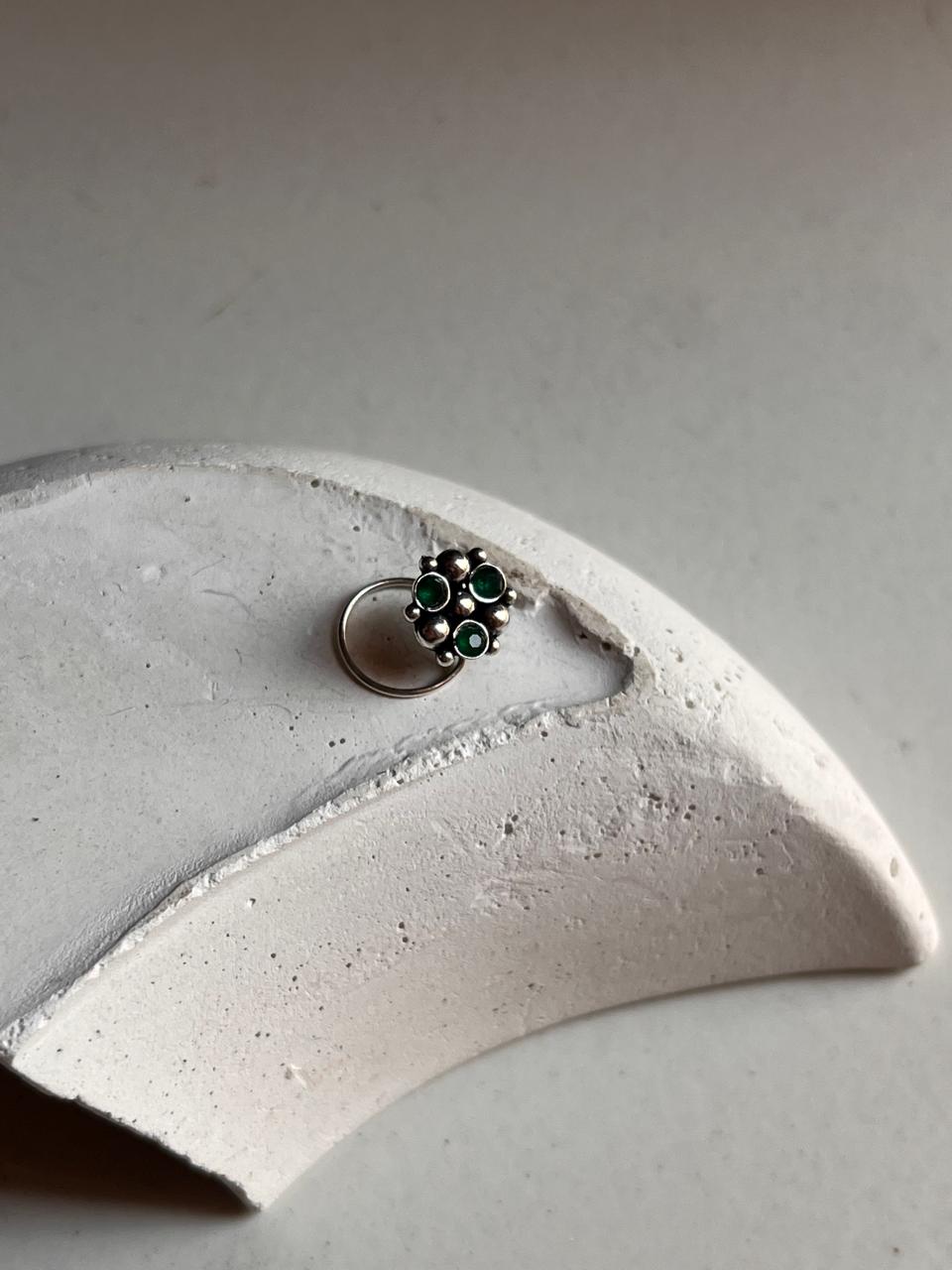 Tribal-style silver nose pin featuring green CZ stone and wired back