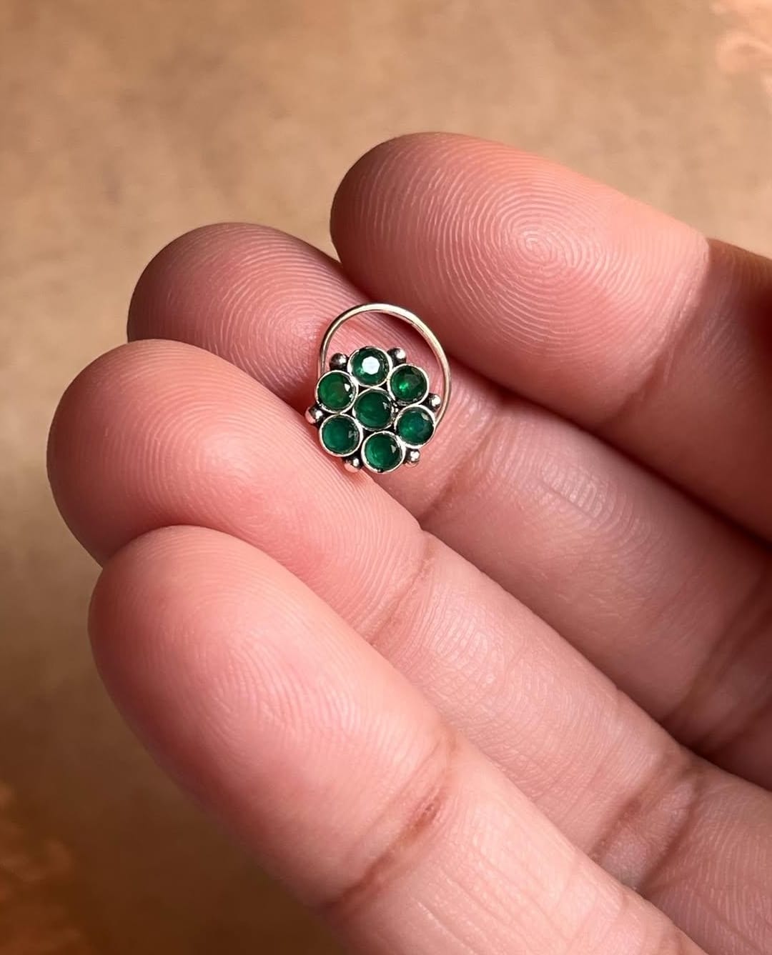 Tribal-style silver nose pin featuring green CZ stone and wired back