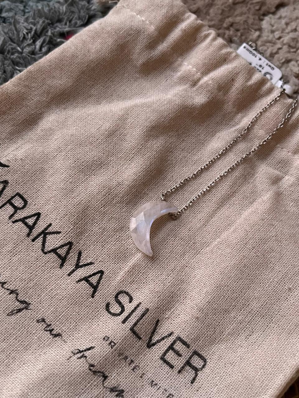 Close-up of Moonstone crescent moon pendant on a crystal silver necklace