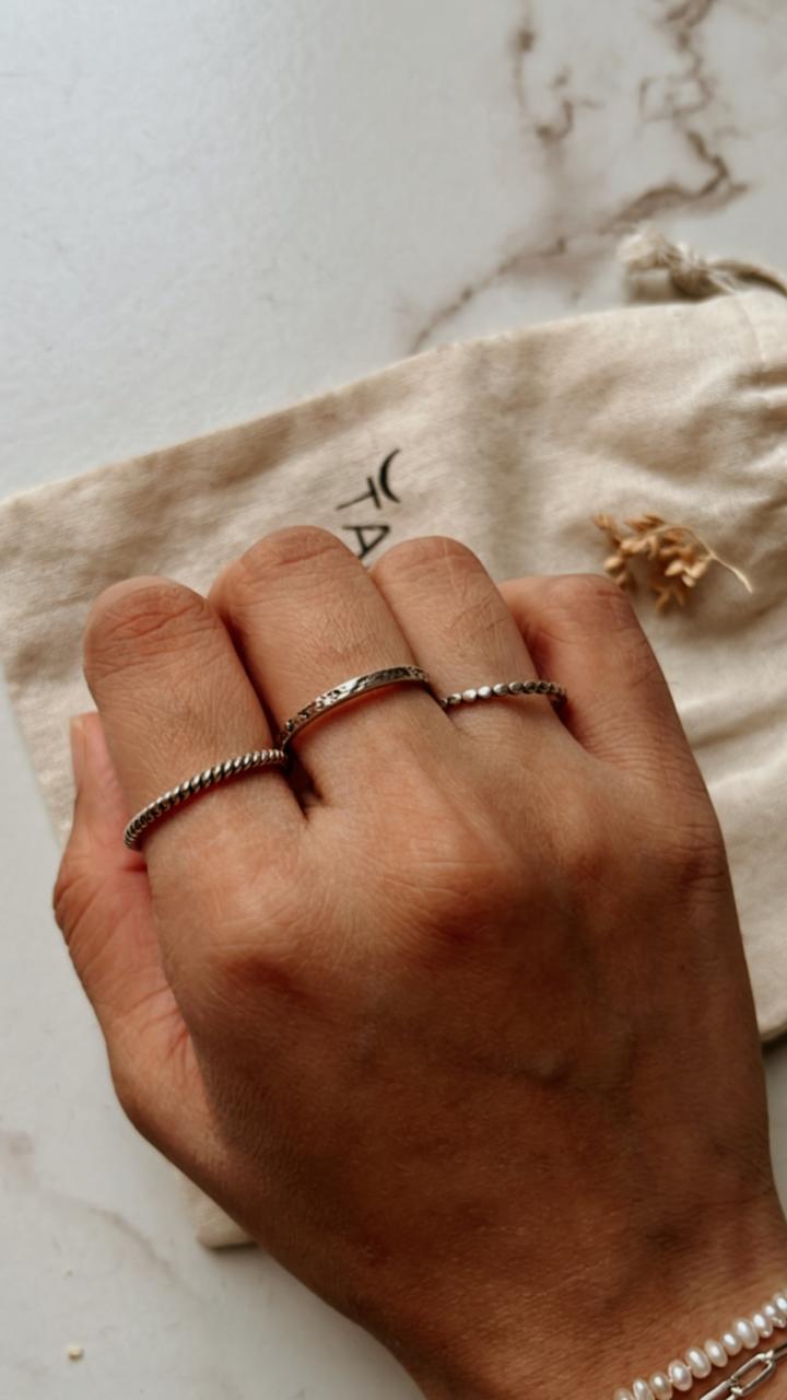 Silver stacking rings with small dot, textured band, and rope pattern