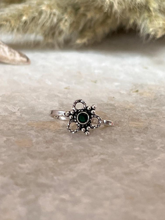 Green flower design sterling silver clip-on with green gemstone centerpiece on a neutral background.