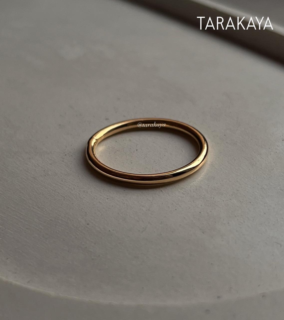 Gold vermeil plain round stack band ring on a neutral background, showcasing its shine and elegant design.
