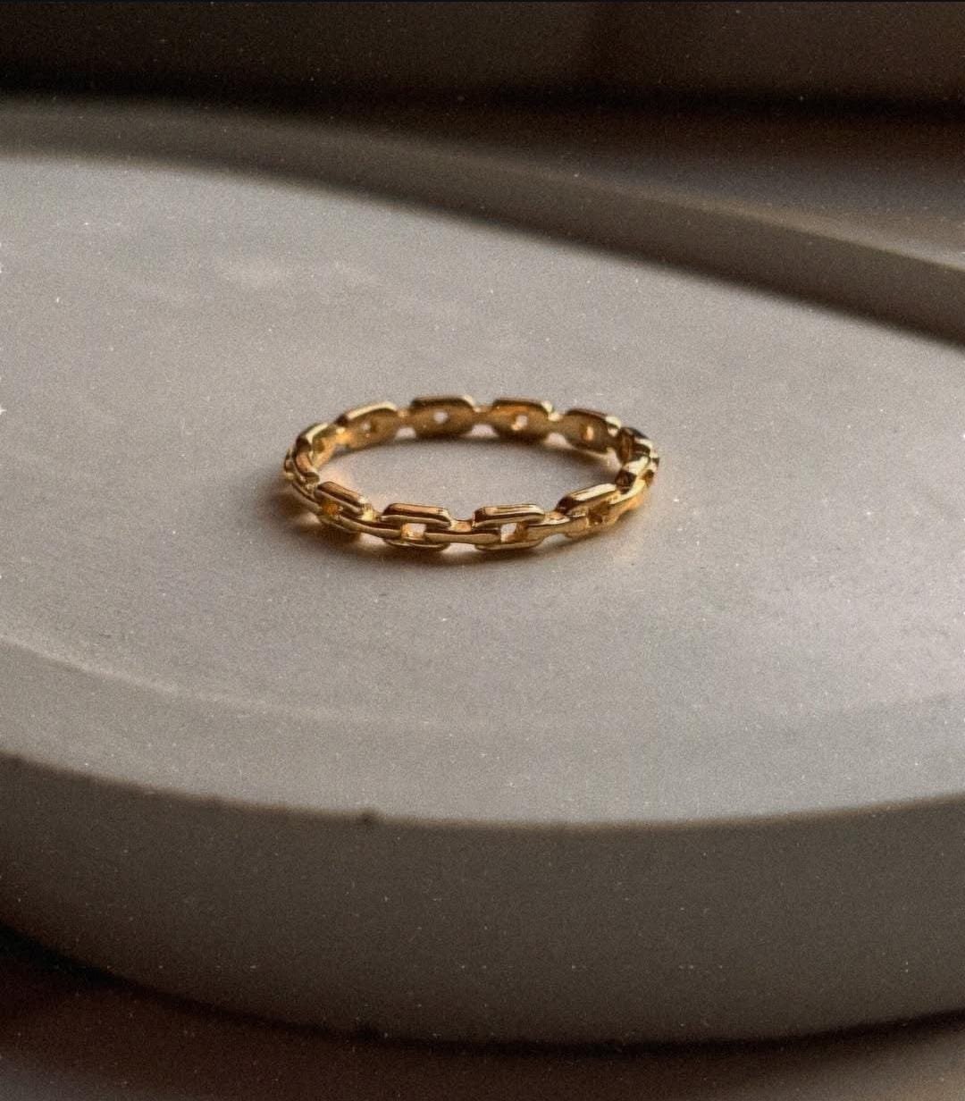 Elegant gold vermeil thin link stack band ring on a smooth surface.