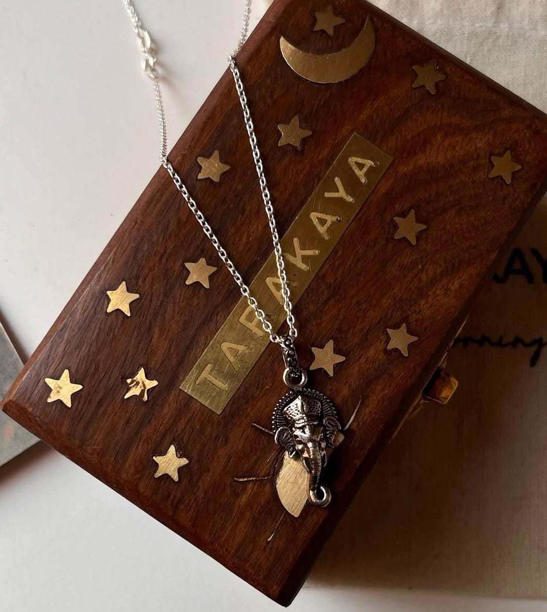 Ganesha face silver pendant on a necklace with a decorative wooden gift box, perfect for unique gifting occasions.