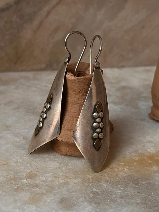 Tribal Handcrafted Rawa Hook 925 Sterling Silver Earrings displayed on a clay holder.