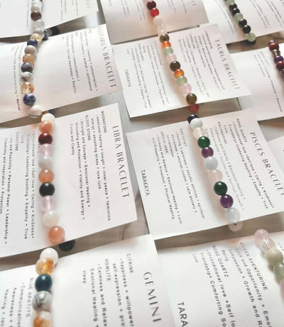 Natural Healing Crystal Intentions bracelets arranged with zodiac and element cards