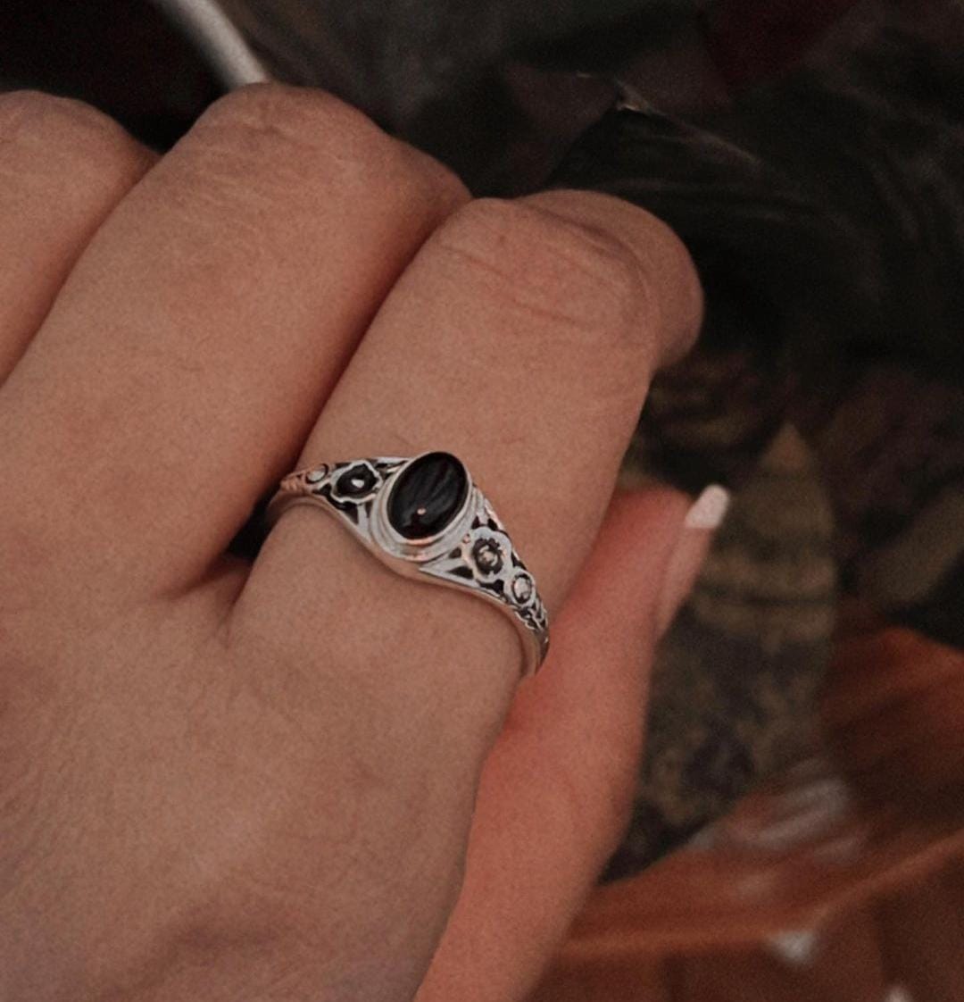 Unique black onyx flower ring with a vibrant stone set in sterling silver.