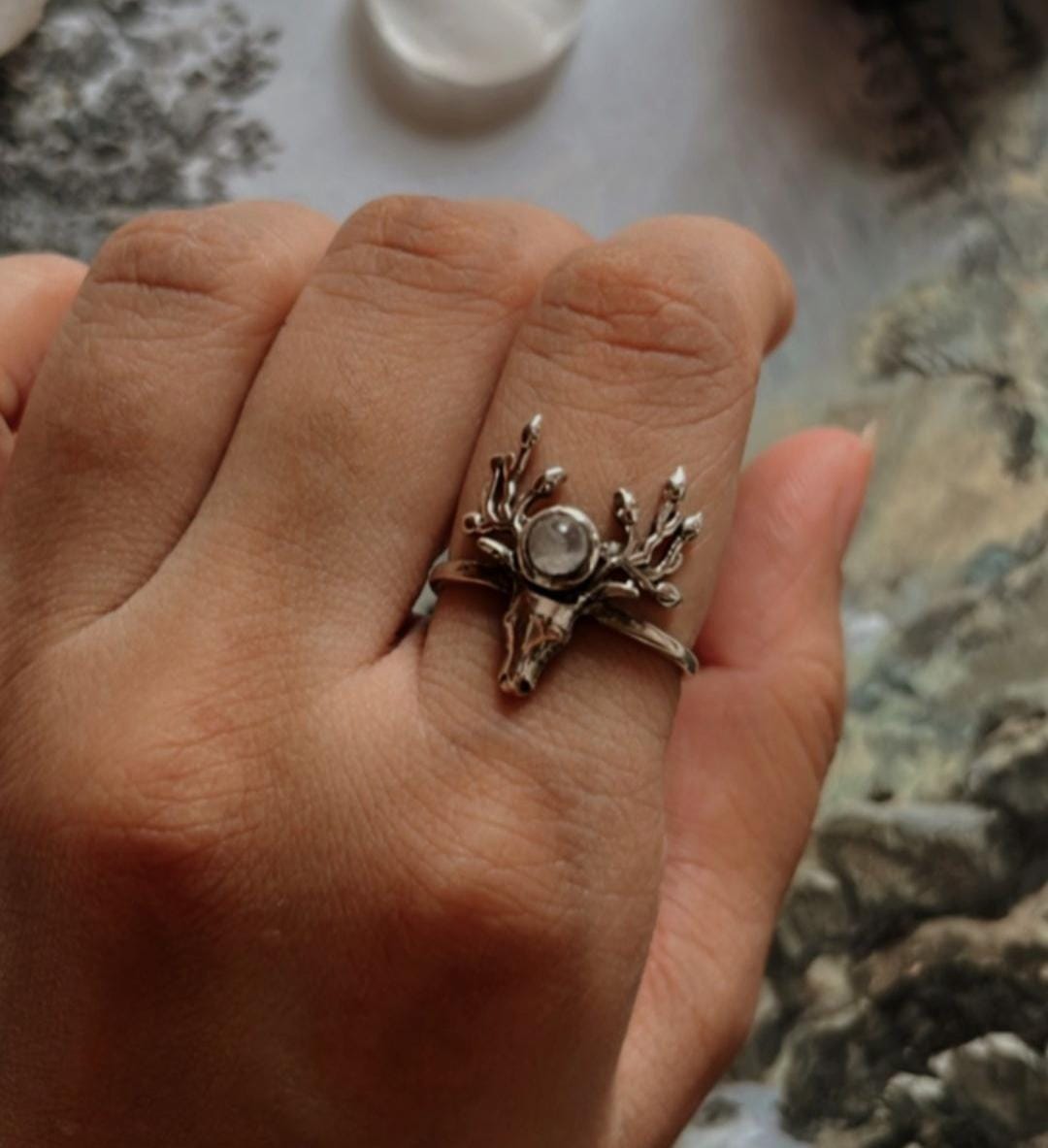 Timeless moonstone silver ring with detailed antler motif.