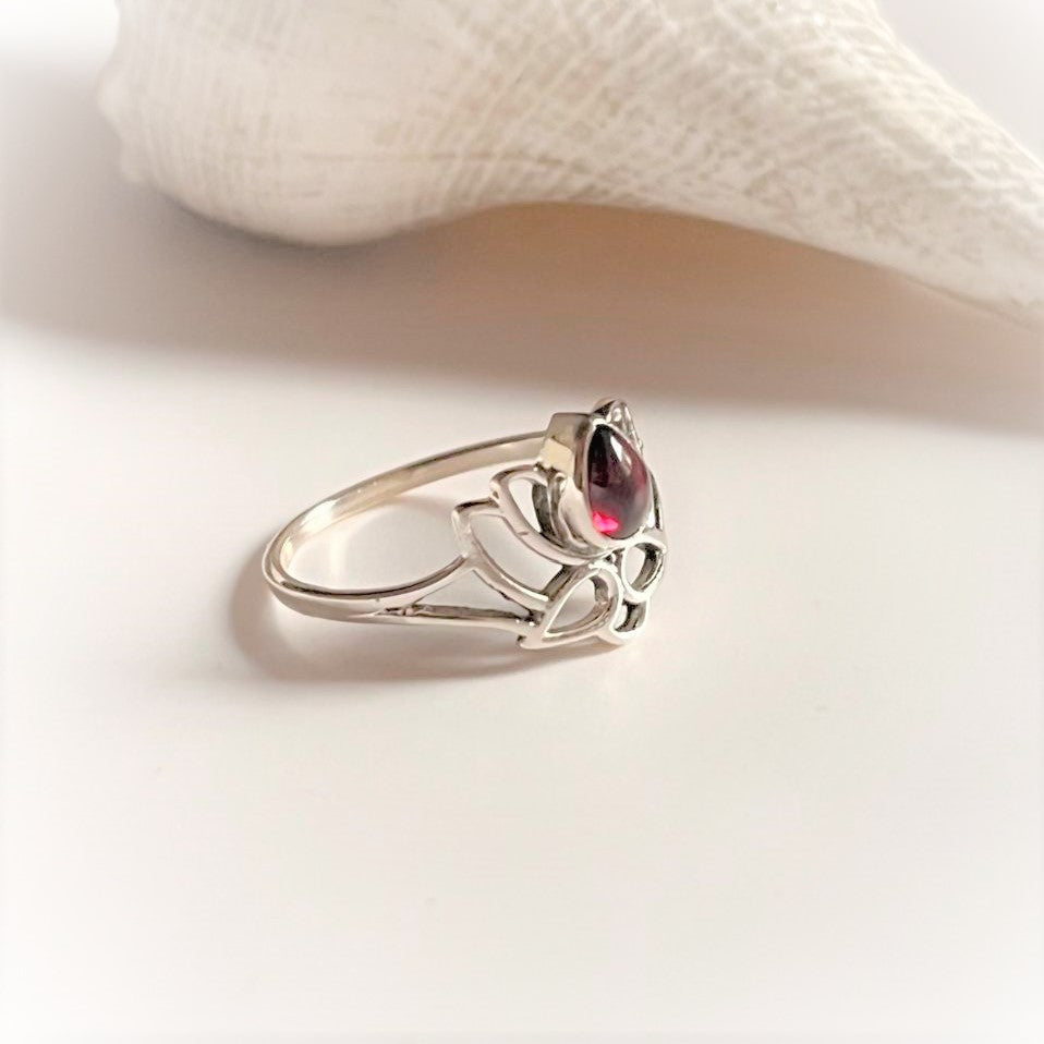 Silver ring with divine lotus pattern and vibrant garnet accent