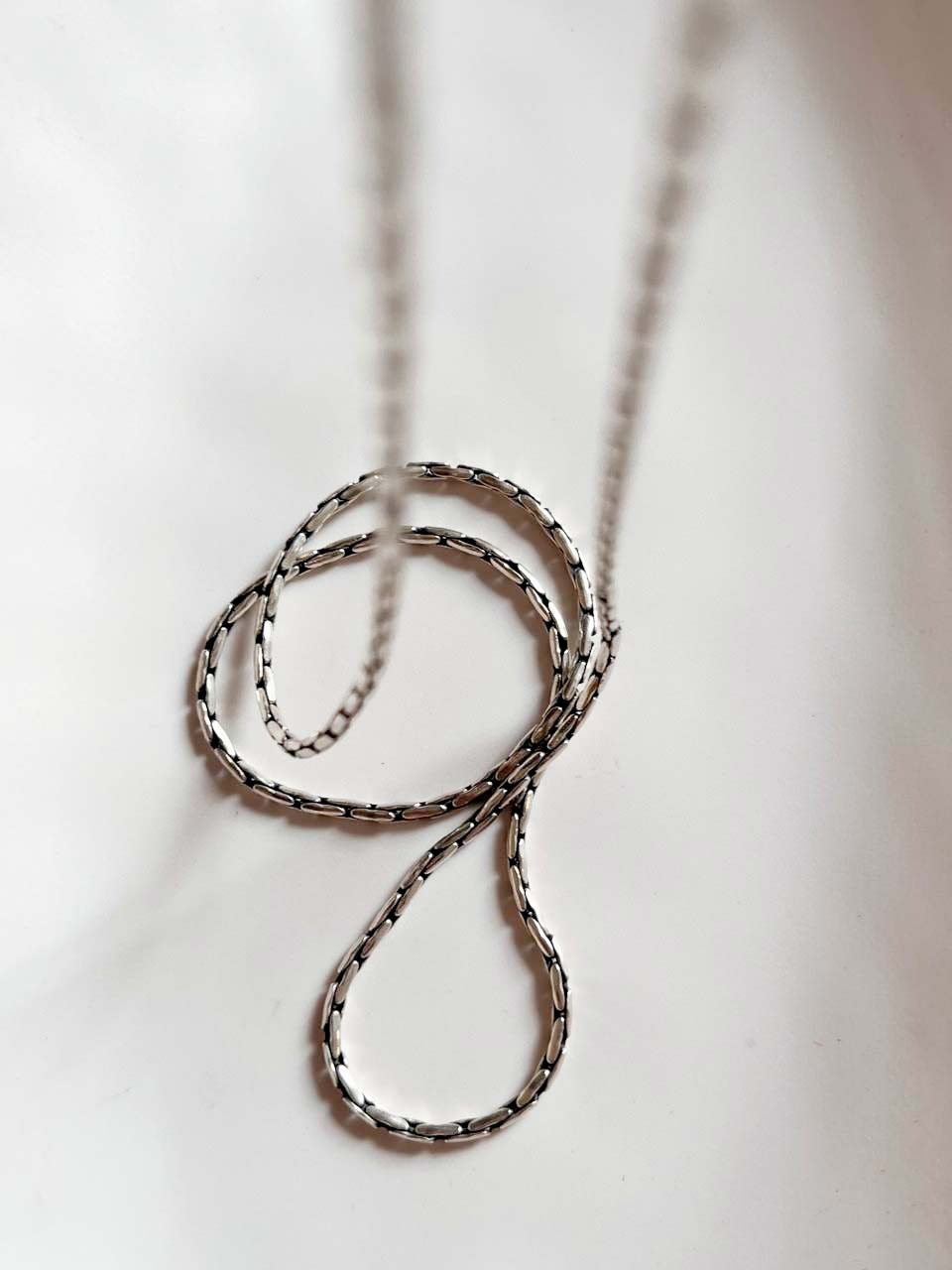 Elegant silver chain with a classic antique pattern design.