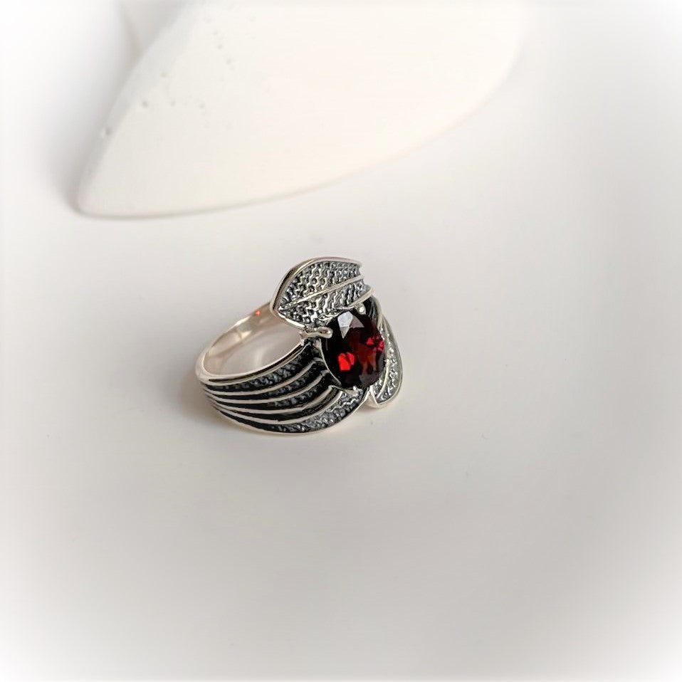 Sterling silver ring featuring a garnet gemstone and leaf wrap design