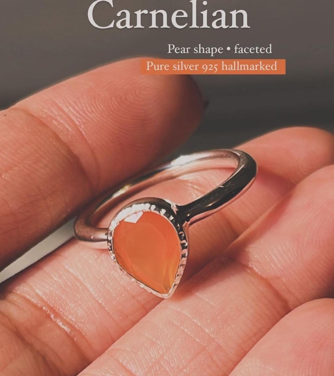 Close-up of carnelian pear stone in a silver ring setting