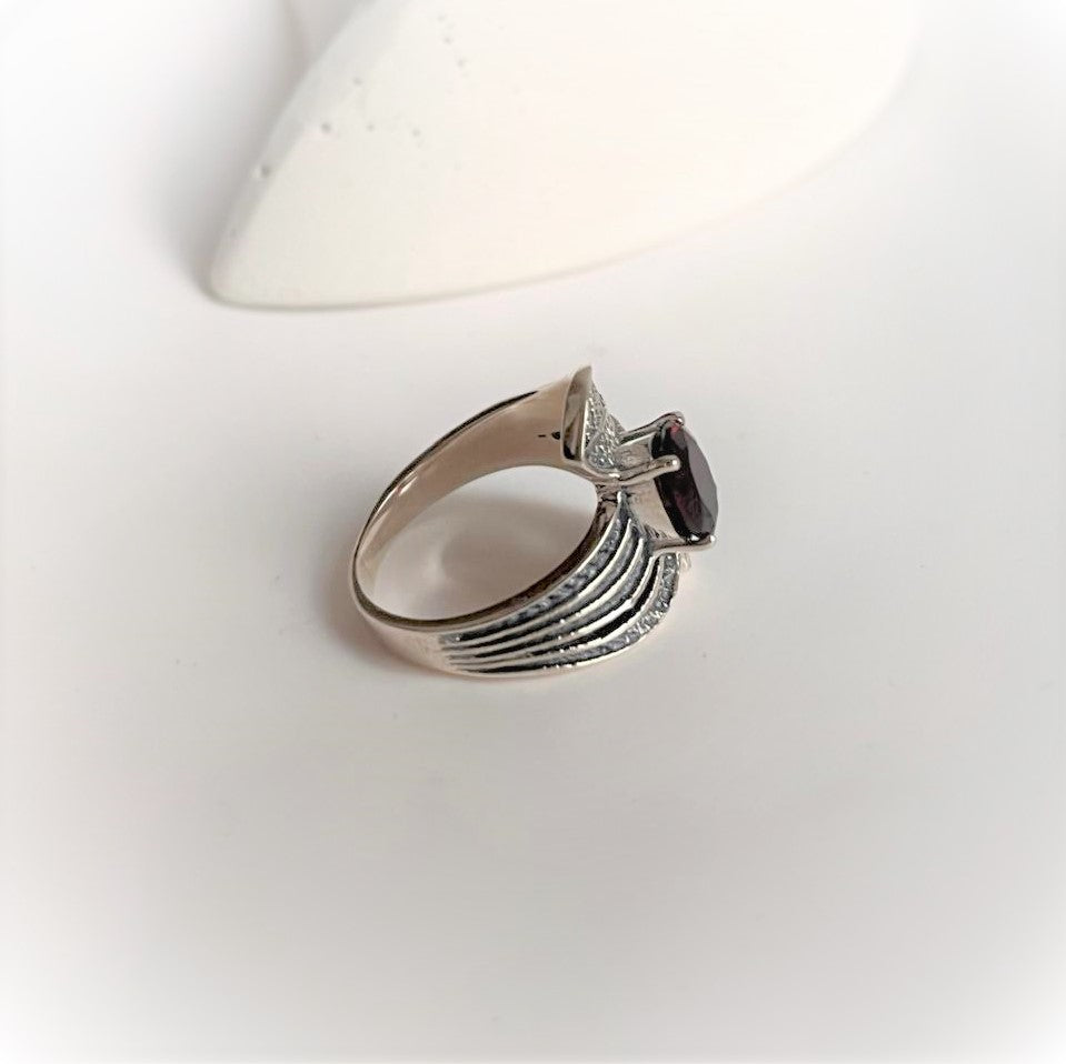 Leaf wrap silver ring adorned with a vibrant garnet stone