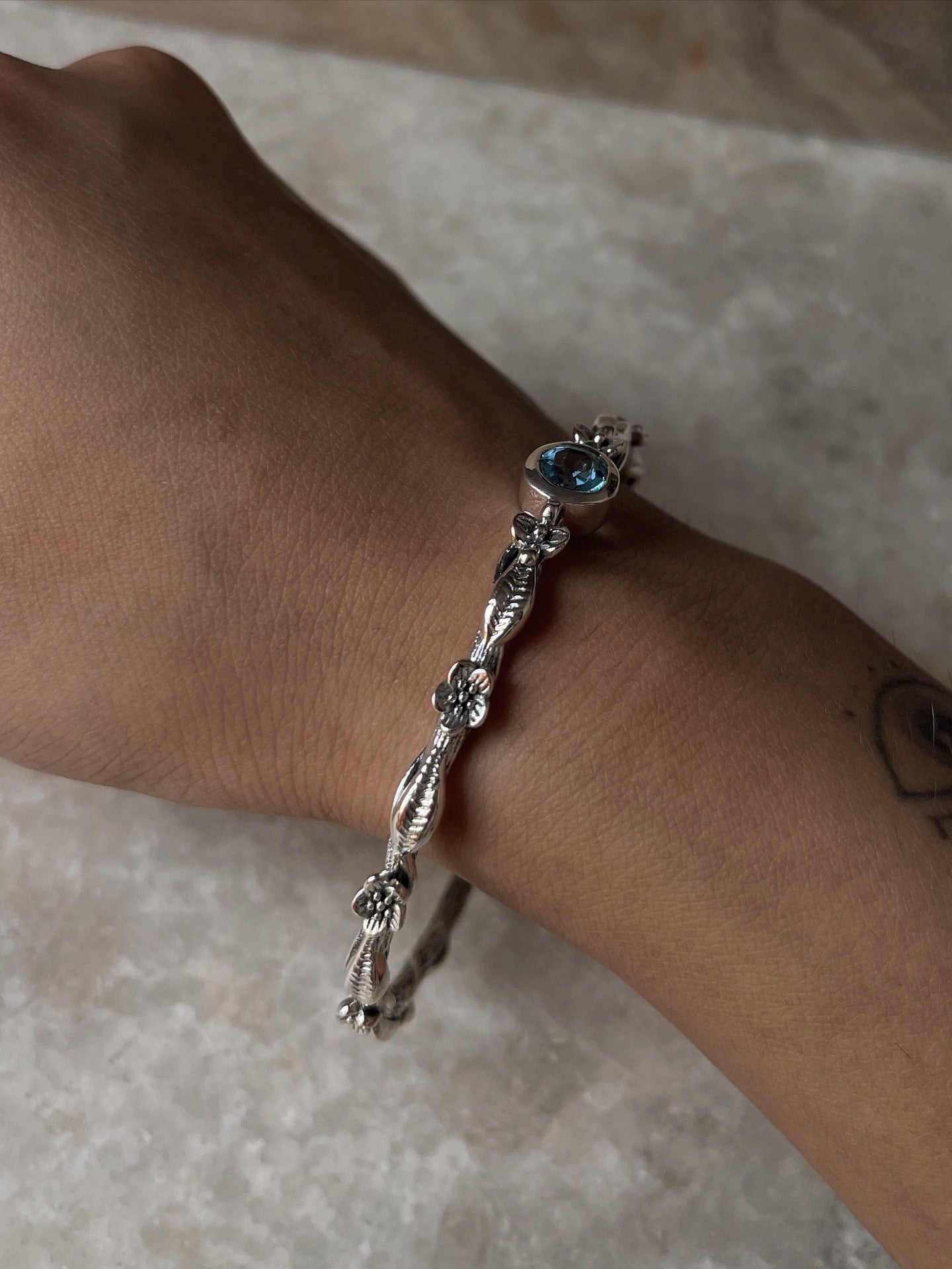 Elegant forest-inspired blue topaz statement bangle in 925 silver