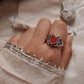 Close-up of a bold carnelian silver ring on a finger
