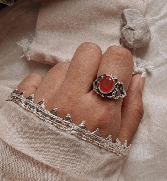 Close-up of a bold carnelian silver ring on a finger