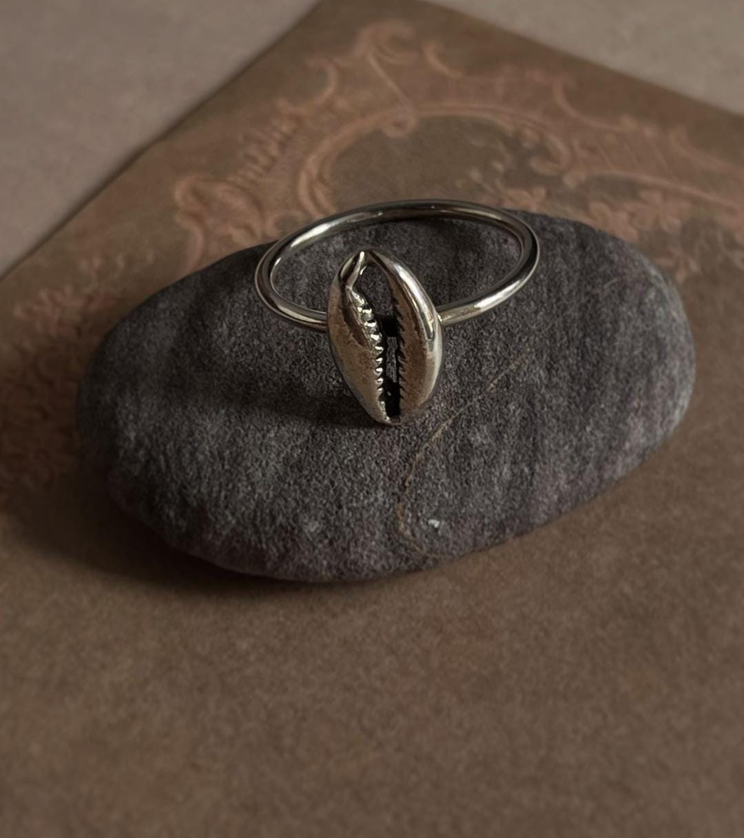 Sleek and stylish cowrie seashell set in a polished silver ring