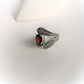 Silver ring with a garnet centerpiece and leaf wrap design