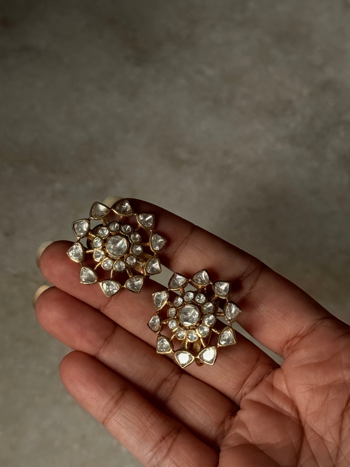 Pair of 925 Sterling Silver Gold Plated Antique Moissanite Polki Earrings held in hand.