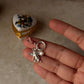 925 Sterling Silver Cherub Angel charm with Clear Quartz heart and Pearl charm in hand on marble surface.