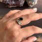 Handcrafted adjustable silver ring with a black onyx stone and feather details.