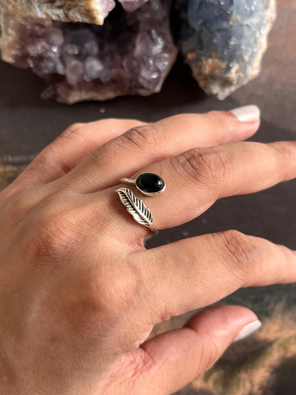 Handcrafted adjustable silver ring with a black onyx stone and feather details.