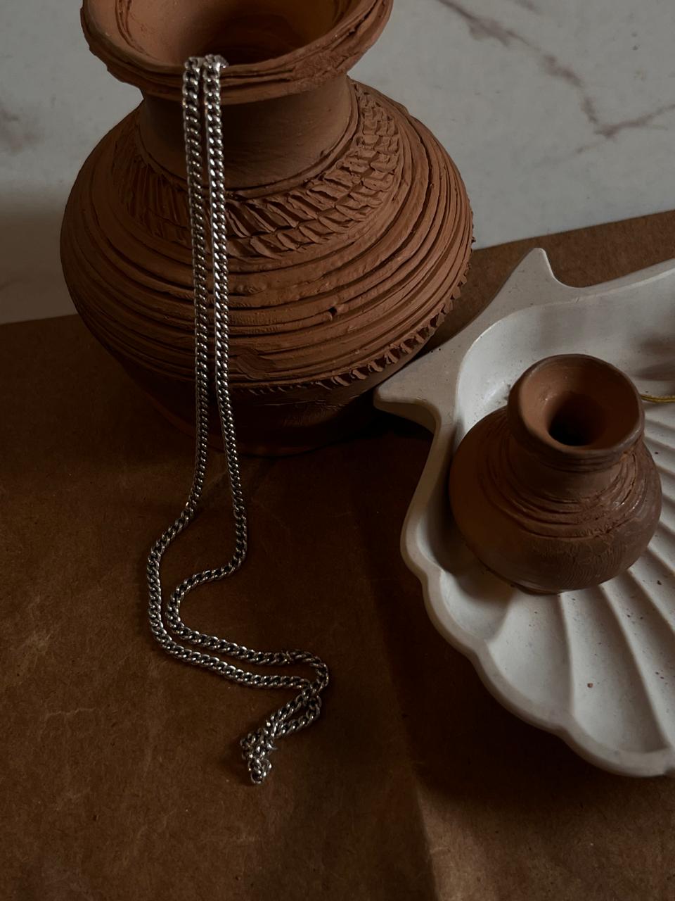Close-up of medium thick curb silver chain with smooth finish