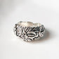 Close-up of adjustable silver ring with intricate garden motif