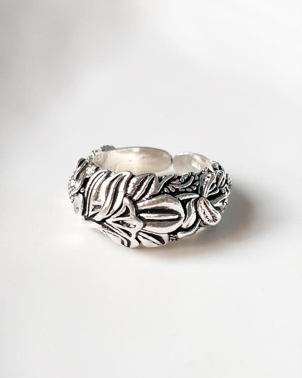 Close-up of adjustable silver ring with intricate garden motif
